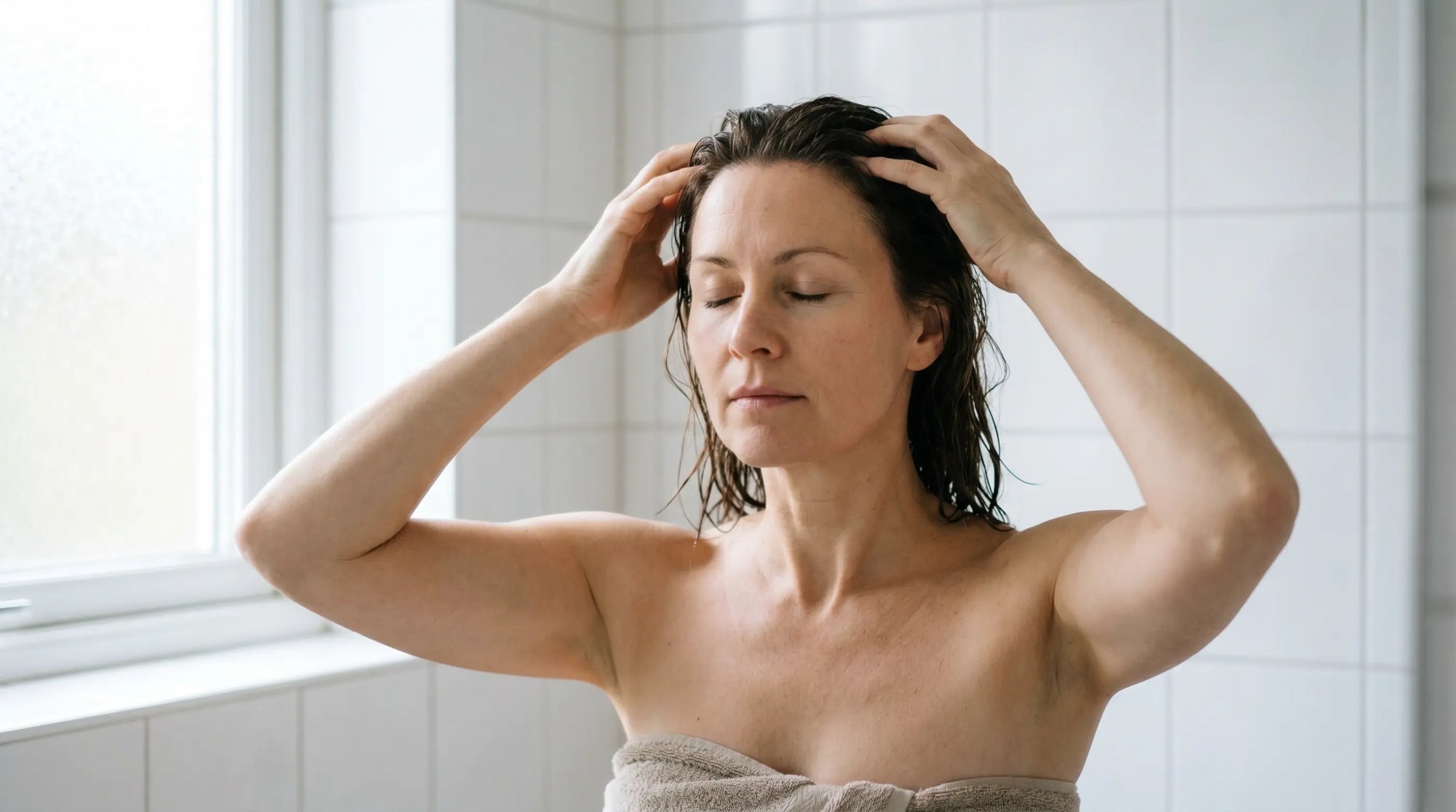 Woman massaging her scalp with fingertips to stimulate hair growth
