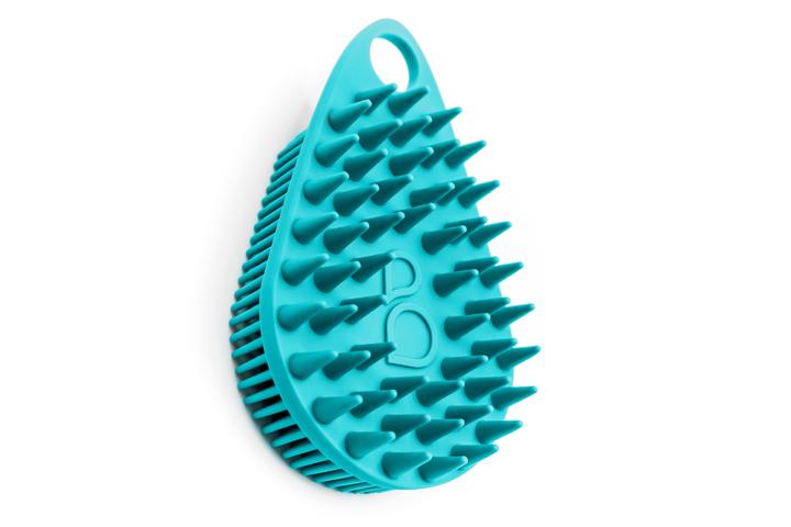 A blue hair brush for Scalp and Body Scrubber - Tahiti Teal by Scrub-dub™ on a white background.