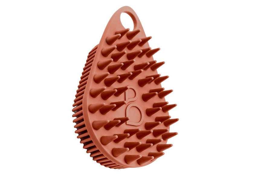 A Scalp and Body Scrubber - Sedona Red from Scrub-dub™, with spikes on it, for daily cleansing routine and skincare needs.