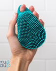 A person holding a Scalp and Body Scrubber - Tahiti Teal in their hand while scrub-dubbing.