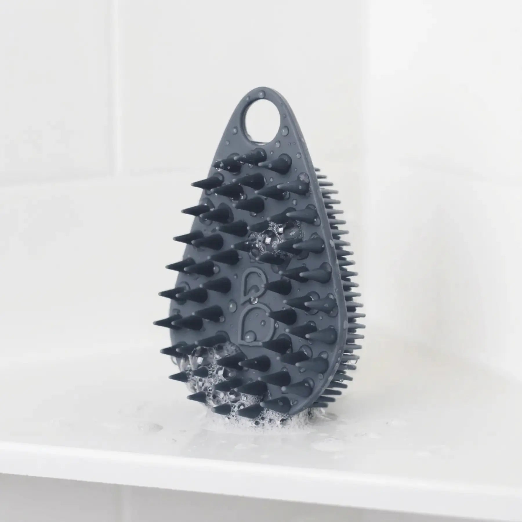 Scrub-Dub® scalp scrubber in a bathroom setting, showcasing its dual-sided design for effective scalp cleaning.