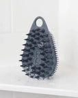 Scrub-Dub® scalp scrubber in a bathroom setting, showcasing its dual-sided design for effective scalp cleaning.