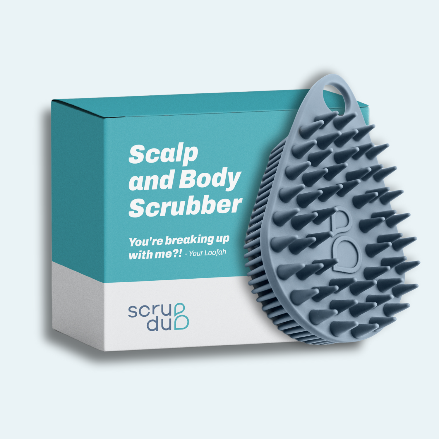 The teardrop-shaped scrubber with protruding bristles is displayed against a turquoise box labeled "The scrub-dub® Scalp and Body Scrubber," by Scrub-dub®, perfect for effortlessly exfoliating your skin.