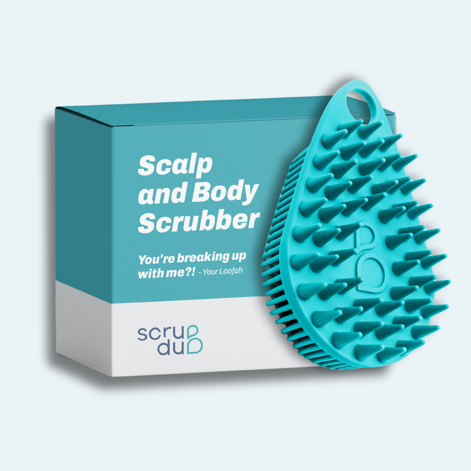 Teal exfoliating scalp and body scrubber with a box labeled &quot;The scrub-dub® Scalp and Body Scrubber&quot; and &quot;You&#39;re breaking up with me?! -Your Loofah&quot; by Scrub-dub®.