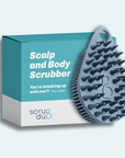 The teardrop-shaped scrubber with protruding bristles is displayed against a turquoise box labeled "The scrub-dub® Scalp and Body Scrubber," by Scrub-dub®, perfect for effortlessly exfoliating your skin.