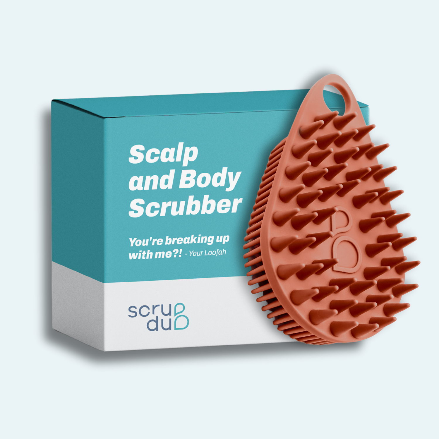 A teal and white box featuring the &quot;The scrub-dub® Scalp and Body Scrubber&quot; from Scrub-dub® contains an orange, spiky, teardrop-shaped scrubber intended for skin exfoliation.