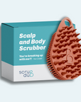 A teal and white box featuring the "The scrub-dub® Scalp and Body Scrubber" from Scrub-dub® contains an orange, spiky, teardrop-shaped scrubber intended for skin exfoliation.