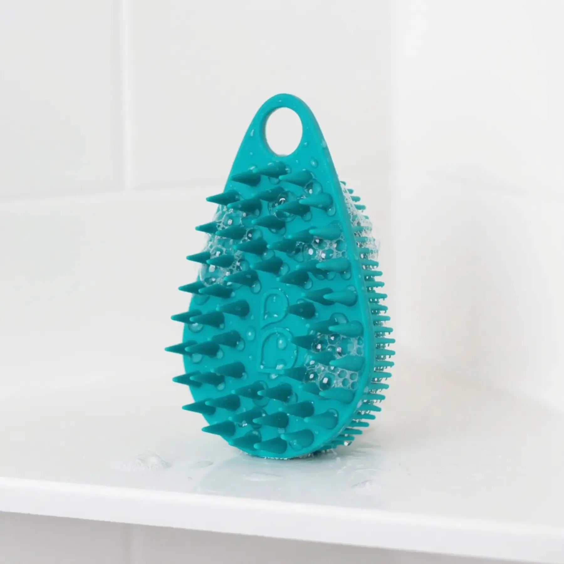 Scrub-Dub® scalp scrubber in teal color, designed for effective scalp cleaning and exfoliation.
