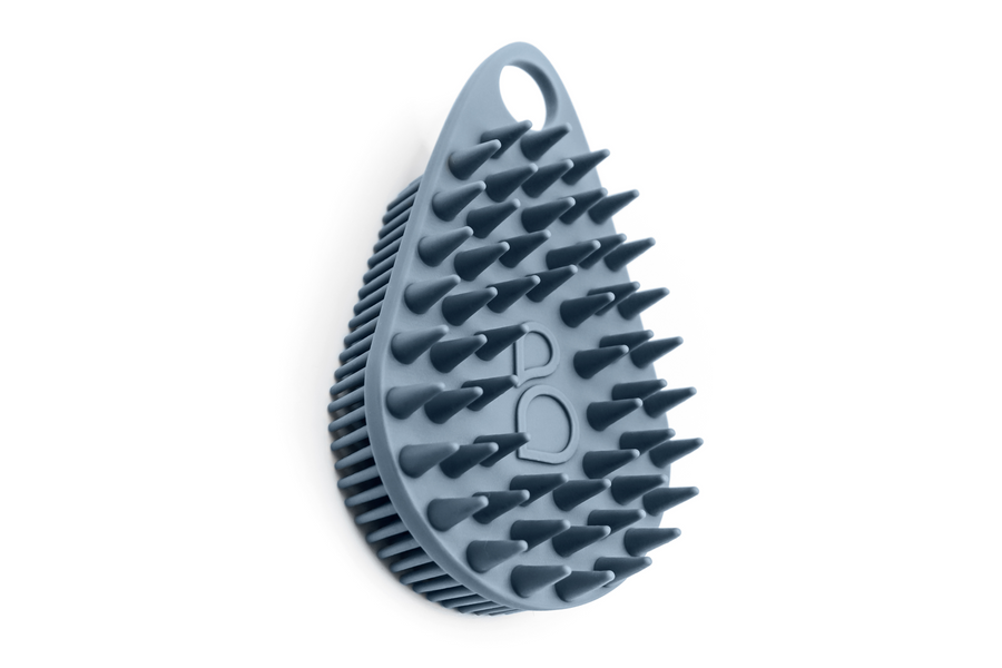 A Scalp and Body Scrubber - Glacier Blue from Scrub-dub™, with spikes on it, can be used as a body scrubber to exfoliate the skin.